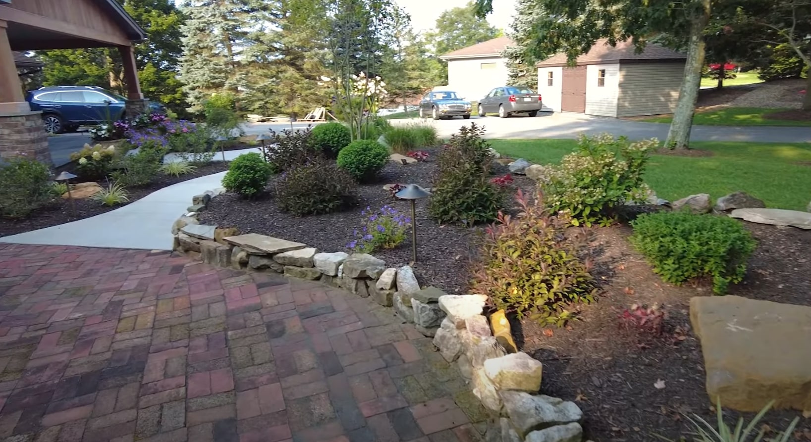 Expert retaining wall and hardscape installation in Pflugerville Professional hardscape design with stone retaining walls and landscaped flower beds