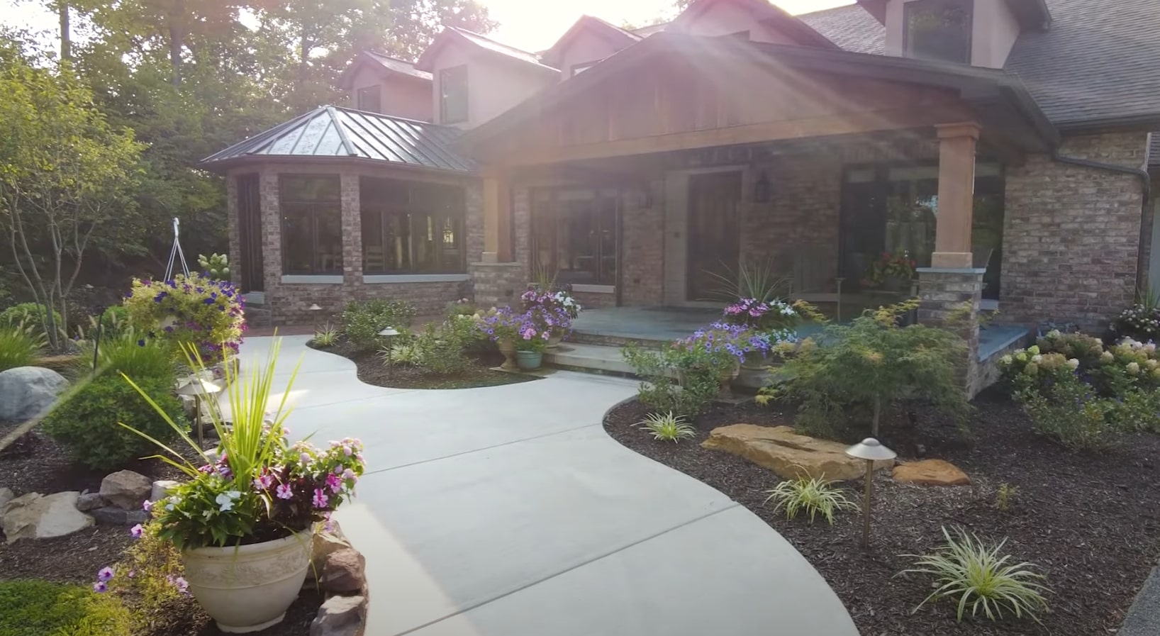 Custom patio design with stone work and beautiful container plantings Elegant patio area with professional hardscaping and container gardens